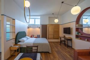 a bedroom with a bed and a desk in a room at Cozy Baity Tbilisi in Tbilisi City