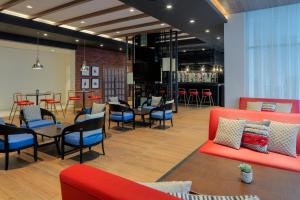 a restaurant with red and blue furniture and a bar at Hyatt Place Dubai Jumeirah in Dubai