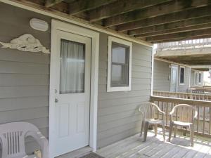 a porch with two chairs and a door at NC 12 56821-26 Condo in Hatteras