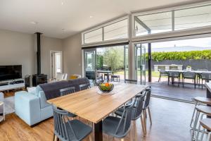 a living room with a wooden table and chairs at Wind Down on Esther in Martinborough  +24 photos