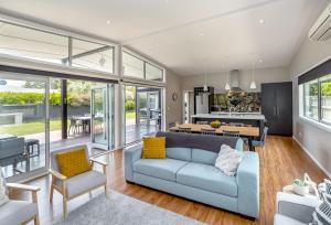 a living room with a blue couch and a table at Wind Down on Esther in Martinborough 