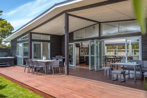 a wooden deck with tables and chairs on a house at Wind Down on Esther in Martinborough 