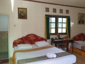 מיטה או מיטות בחדר ב-Putri Duyung Guest House