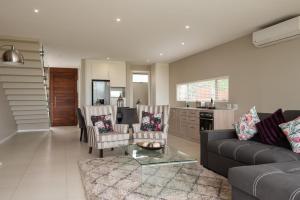 a living room with a couch and chairs and a table at 65A Zimbali Wedge in Ballito