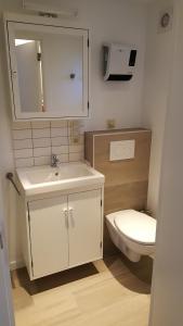 a bathroom with a white sink and a toilet at Vakantiehuisje Lora in Middelkerke +7 photos