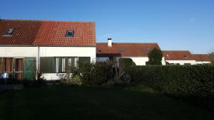 a house with a red roof and a yard at Vakantiehuisje Lora in Middelkerke