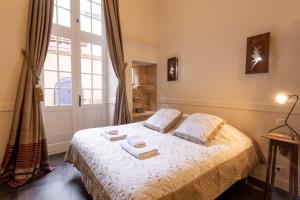 a bedroom with a bed with two towels on it at Heart of Sarlat in Sarlat-la-Canéda