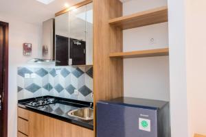 eine kleine Küche mit Spüle und Kühlschrank in der Unterkunft Minimalist Studio Apartment at Casa De Parco By Travelio in Samporo