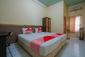 a bedroom with a large bed with red and white pillows at OYO Life 2502 Syariah Triantama Kost in Palembang
