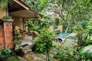 a house with a swimming pool in a garden at Desak Putu Putra Hidden in Ubud