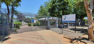 a metal gate with a sign in front of it at Acacia Westdene B&B in Bloemfontein