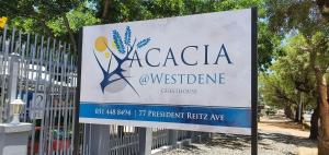 aan een hek is een bord voor aucadiawesterncellence bevestigd bij Acacia Westdene B&B in Bloemfontein