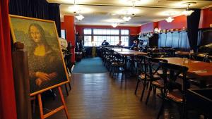 a room filled with tables and chairs and a painting on the wall at Law Courts Hotel in Dunedin