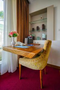 a desk with a vase of flowers and a chair at Ocean View Residence in Jepara