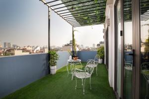 a patio with chairs and tables on a balcony at Serene Boutique Hotel & Spa in Hanoi