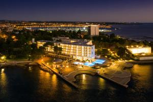 a city at night with a large body of water at Hotel Sipar Plava Laguna in Umag