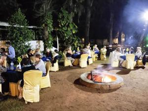 a group of people sitting in chairs around a fire at Hassan Ashok in Hassan