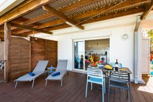 a patio with a table and chairs on a deck at T2A Lagon Austral "Jardin du lagon" in Saint-Pierre
