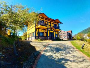 a large yellow house with a road in front of it at 南投清境挪威森林 in Renai
