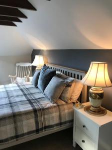 a bedroom with a bed and two lamps on a night stand at Harleyburn Cottages - Stables and Saddlery in Melrose