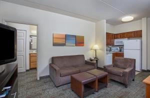 a living room with a couch and a chair and a tv at Staybridge Suites Chattanooga Downtown - Convention Center by IHG in Chattanooga