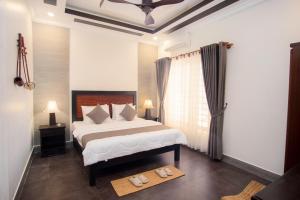 a bedroom with a bed and a window and a table at Sala Kanseng Home in Siem Reap