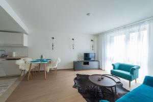 Vienna Calling - Self Check-in في فيينا: غرفة معيشة مع أريكة زرقاء وطاولة