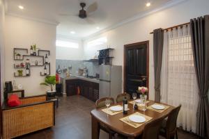 a dining room with a table and a kitchen at Sala Kanseng Home in Siem Reap
