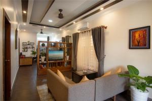 a living room with a couch and a tv at Sala Kanseng Home in Siem Reap