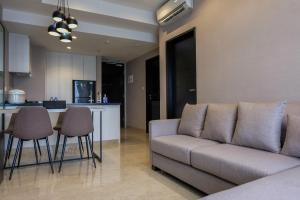 ein Wohnzimmer mit Couch und Küche in der Unterkunft Fully Furnished 1BR at Branz BSD City Apartment By Travelio in Samporo