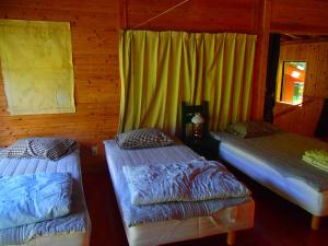 two beds in a room with yellow curtains at 屋久島コテージ対流山荘 in Yakushima