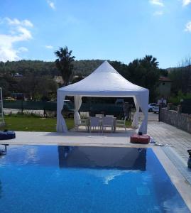 a white tent sitting next to a swimming pool at Paddys Apartments, Hisarönü in Fethiye
