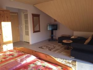 a room with a bed and a couch and a tv at Die Ferienwohnung Lindenhof in Zell an der Mosel