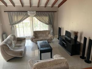 a living room with two couches and a tv at White House lodge in Scotburgh in Scottburgh