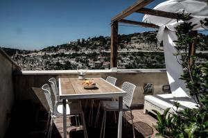 una mesa y sillas en un balcón con vistas en Anime a Sud - Casa Kimiyà en Modica