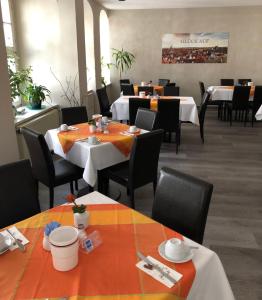 Hotel Am Obermarkt في فرايبرغ: غرفة طعام مع طاولات وكراسي في مطعم
