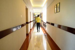 un hombre caminando por un pasillo en un pasillo del hospital en The Classic Hotel, en Imphal