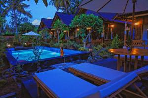 a resort with a swimming pool and a table and chairs at Mertasari Bungalows in Nusa Penida +26 photos