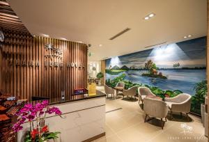 Thanh Long Hotel - Bach Dang في مدينة هوشي منه: غرفة انتظار مع كراسي و لوحة على الحائط