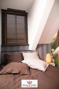 1 dormitorio con 1 cama grande y ventana en House of Tulips en Hillegom
