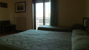 a hotel room with two beds and a window at Hotel Due Pini in Melfi