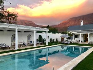 a swimming pool in front of a house at La Cotte The Manor House in Franschhoek