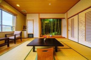 sala de estar con mesa y sillas en Tenku Yubo Seikaiso en Beppu