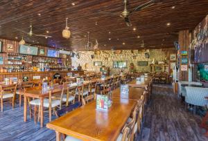 a restaurant with wooden tables and chairs and a bar at Antonis G. Hotel Apartments in Oroklini