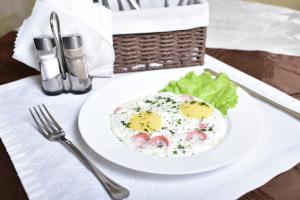 a white plate with an egg and salad on a table at Hotel Aeroport in Barnaul
