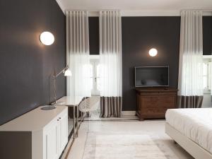 1 dormitorio con 1 cama, escritorio y TV en Villa Corallo, en SantʼOmero