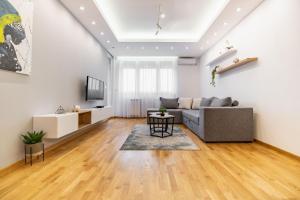 uma sala de estar com um sofá e uma mesa em Arena BIG Luxury Apartments em Novi Sad