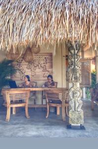 two people sitting at a table in a restaurant at Incense Impossible Beach-Adults Only in Uluwatu
