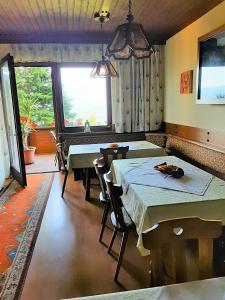 a dining room with two tables and a window at Birkenhof in Millstatt