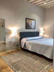 1 dormitorio con 1 cama, 2 lámparas y 1 alfombra en Appartamento Mariapaola en Arezzo
